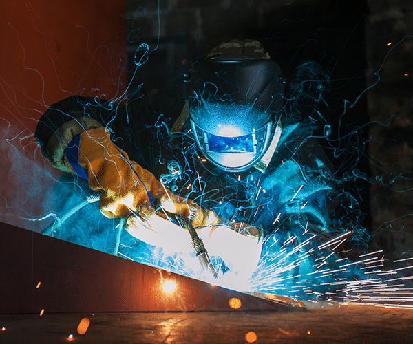 Welder working on a project with faceshield on and sparks flying